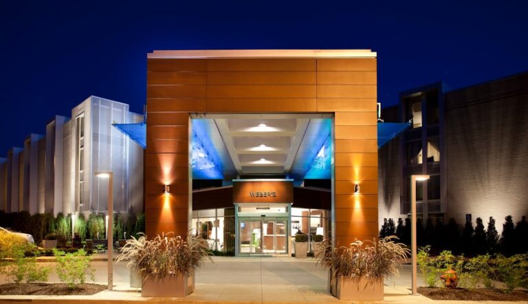 Lit entrance of Weber's Boutique Hotel on Jackson Avenue at dusk